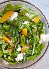 Kale and Citrus Salad with white cheese in a bowl